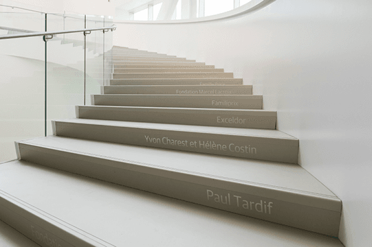 Gros plan sur les marches d'un escalier en colimaçon blanc. 
